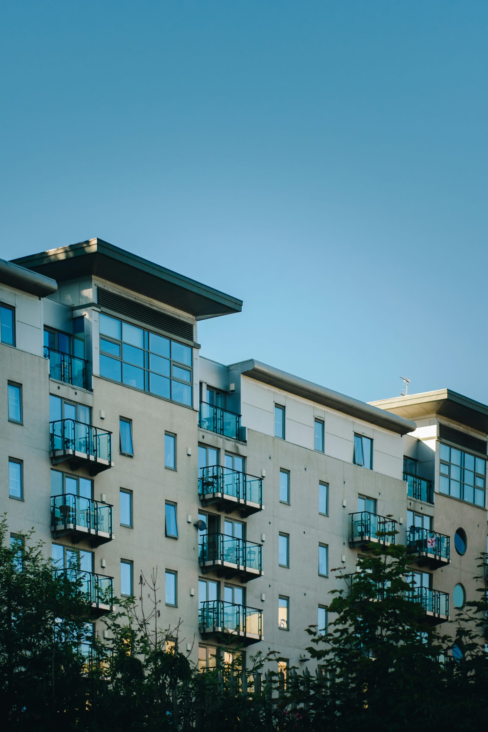 A modern low-rise apartment building with balconies, of the kind used for provided accommodation.