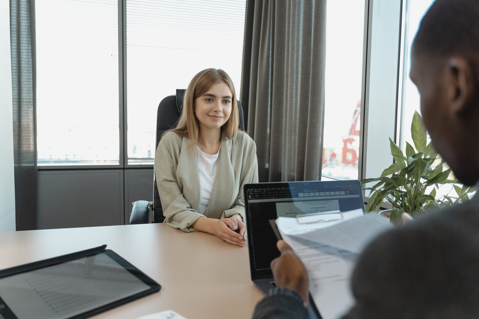 A new joiner sitting across a desk from an HR representative who is going through their paperwork.